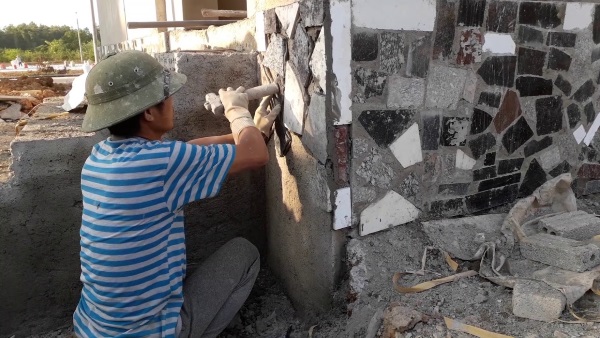 Thợ nghề đang thực hiện kỹ thuật ốp đá vào tường